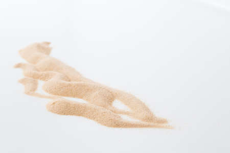 Yellow sand heap isolated on white backgroundの写真素材