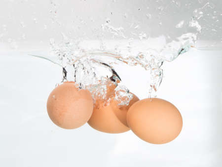 Three eggs in boiling water on the white
