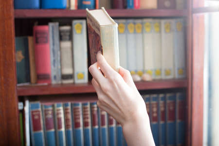 Woman is  borrow a book from the library