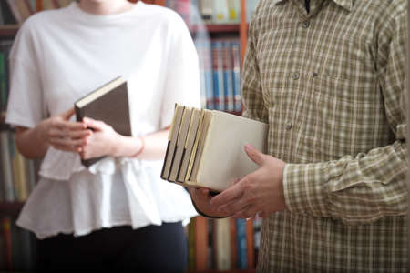 Boy and girl students with books in the library
