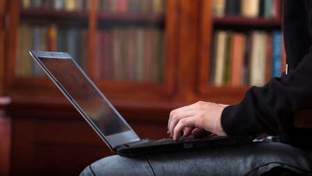 Schoolboy is working for exams on laptop in library