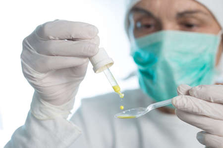 The medic prepares an oral vaccine with pipette and spoon