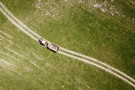 Top view of old  tractor with trailer on the pastureの写真素材