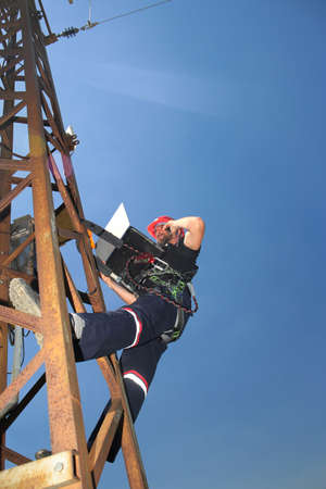 Technician programming 5G radio link with laptop 