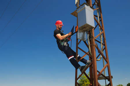 Worker the pole with the multimeter and laptopの写真素材