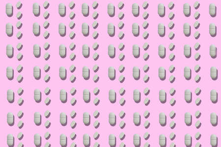 Top view of a group of rounded tablets on a pink backgroundの写真素材