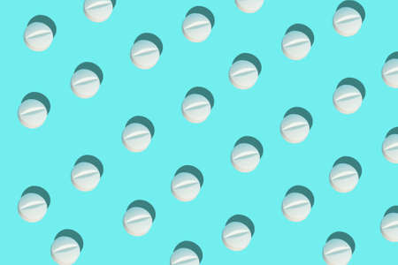 Top view of a group of white pills on a blue background