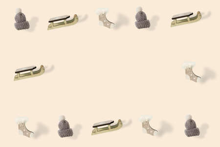 Woolen cap whit white pompon, sled and sock ornament on  champagne background