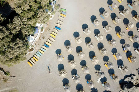 View from above on the Mediterranean sandy beach with umbrellas and sun bedsの写真素材
