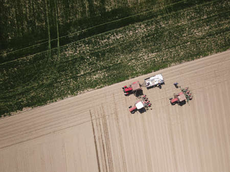 Top view of Three tractors are preparing to fertilize the fieldの写真素材