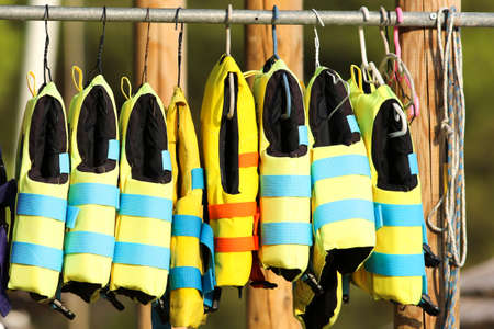 Group of blue and yellow life vest in beach