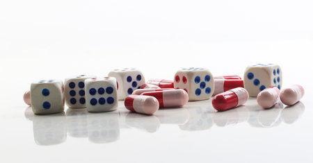 antibiotic capsules and dice on white background.