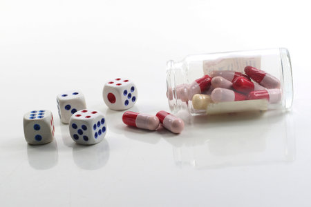 Glass bottle, antibiotic capsules and dice on white background.