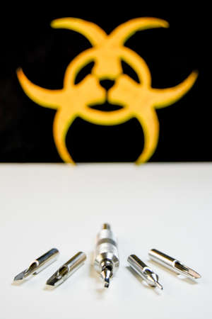 Stainless steel tattoo tube and tips,  with biohazard symbol on black background.の写真素材
