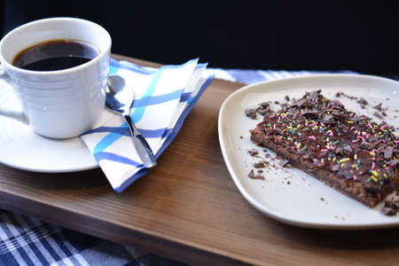 Black coffee on a white cup with mocca bit pastry.の写真素材