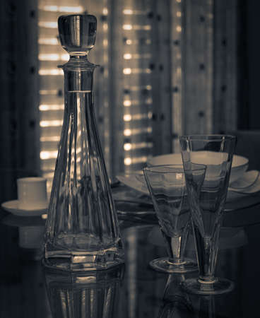 Modern plates and glasses out on the glass tableの写真素材