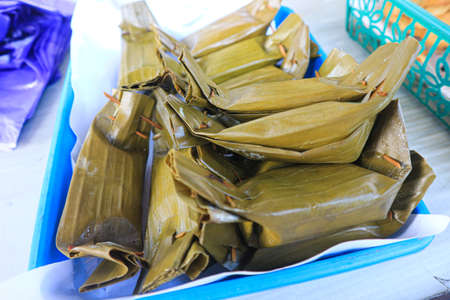 Thai dessert, steamed sticky rice wrapped in banana leaf.の写真素材
