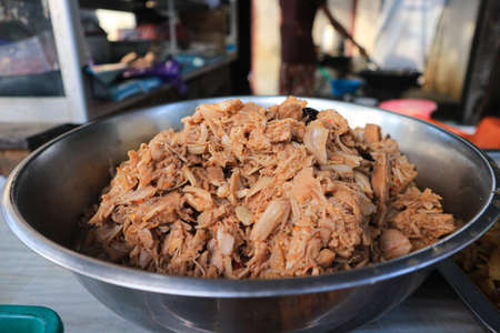 stir fried chicken with onions in a metal bowl on the tableの写真素材