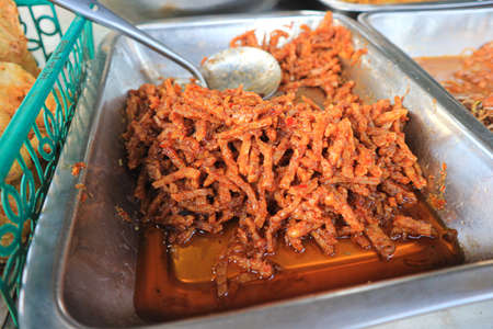 Crispy fried pork with spicy sauce in street food market.の写真素材