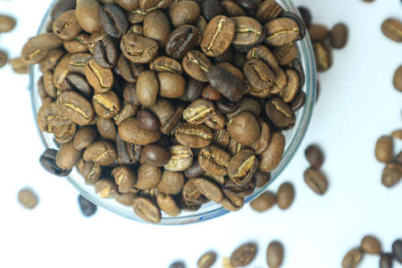 Coffee beans in a glass bowl on a white background.の写真素材