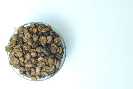 Coffee beans in a glass bowl on a white background.の写真素材