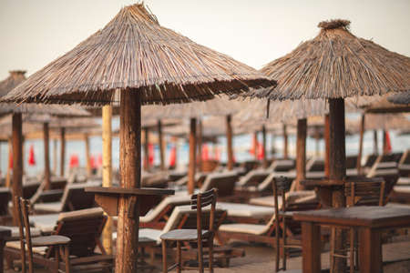 Sun beds and colorful folding umbrellas on the beach. sand, dawn, coast, horizon, blue sky, sea.の写真素材