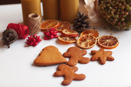 New Years decor. Christmas gingerbread cookies, candles, fir cones, gift wrapping on a white background, space for textの写真素材