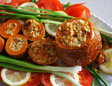 Baked pumpkin with rice stuffing and vegetables の写真素材