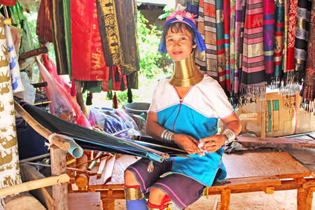 Unidentified Padaung  Karen  tribe woman weave on traditional device near Mae Hong Son, Thailand, Chiang rai, Karen Long Neck hill tribe village  Padaung women wear brass rings on the neck since the age of 5 yearsのeditorial素材