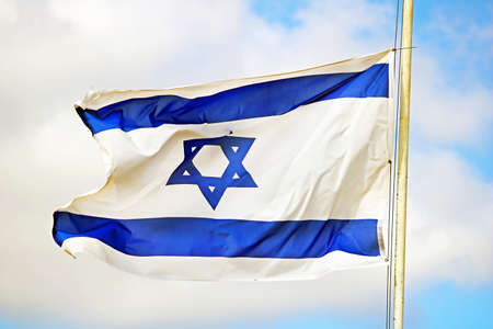 Israel flag close up shot on a background of blue sky. White and blue colors. Israel flag waving against skyのeditorial素材