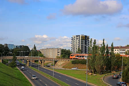 View of orange colored regional train by Elron company and car traffic, Tallinn, Estoniaのeditorial素材