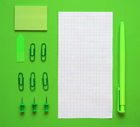 Pen, paper and stationery on a green background. In the green style. The concept of sustainable...