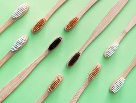 Bamboo toothbrushes on trendy green background. Eco-friendly products. Eco, zero waste and health...