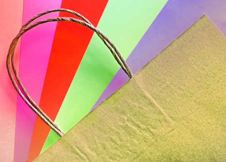 Recycled paper shopping bag on multicolored bright background in trendy colors. Eco and sales concepts. Flat lay. Place for textの写真素材