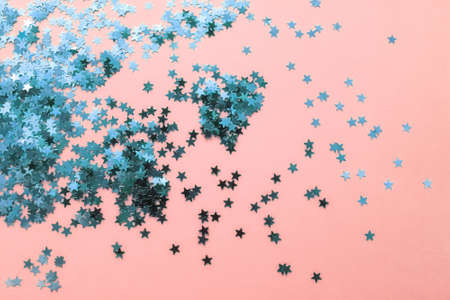 Delicate pink background with blue glitter stars. Flat lay. Holiday concept. New year timeの写真素材