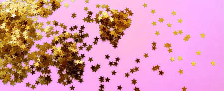 Delicate pink background with golden glitter stars. Flat lay. Holiday concept. New year time. Bannerの写真素材