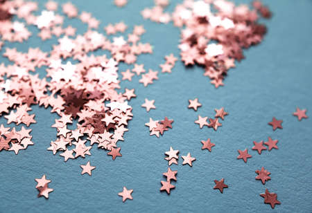 Blue paper background with red glitter stars. Flat lay. Holiday concept. New year time