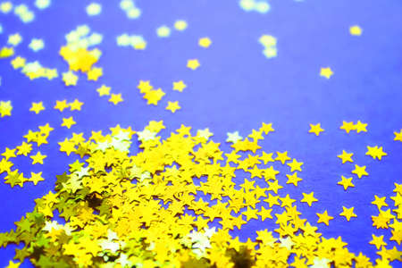 Blue paper background with golden glitter stars. Flat lay. Holiday concept. New year timeの写真素材