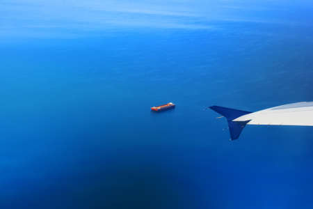 View of the Mediterranean Sea and a barge near Thessaloniki, Greece. View from the plane. Airplane wingの写真素材
