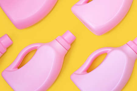 Pink bottles with chemicals for cleaning on a yellow background. Seamless pattern. Cleaning conceptの写真素材