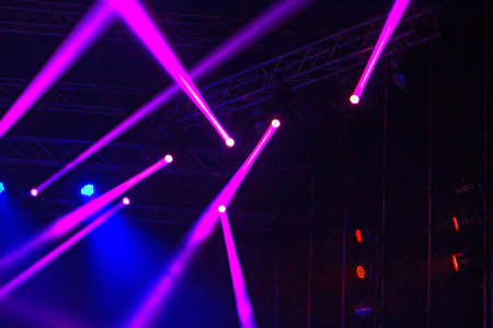 Purple and blue rays of light on stage in the darkの写真素材
