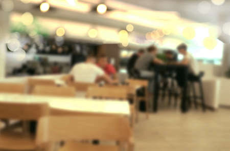 Blurred image of people in modern cafe. Can be used as backgroundの写真素材