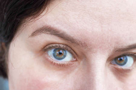 Surprised look of a woman. Close-up view of the eyes. Woman asks a questionの写真素材