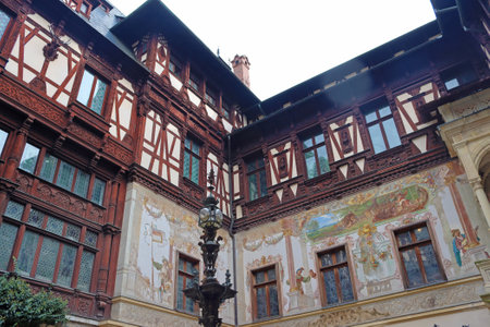 Sinaia, Romania - October 14, 2023: Yard of beautiful Peles castle with painted facade walls and wooden elementsのeditorial素材