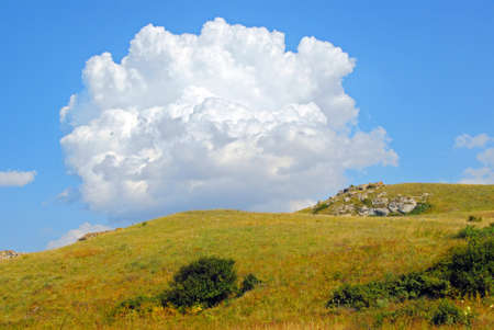 big white cloud over the steppe hill