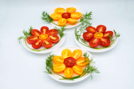 yellow and red flowers from cut ripe and juicy tomatoes on a white backgroundの写真素材