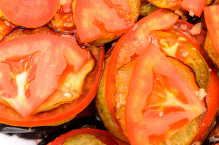 Fried eggplant with tomatoes on the plate and close-upの写真素材