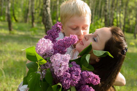 The boy gives flowers to his motherの写真素材