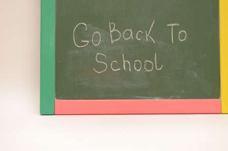School supplies on a background of a school board with an inscription and on a light background
