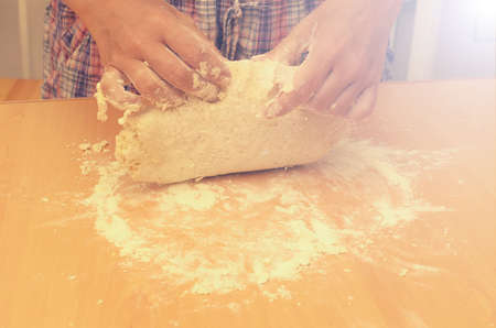 A woman kneads a homemade dough for pizza production